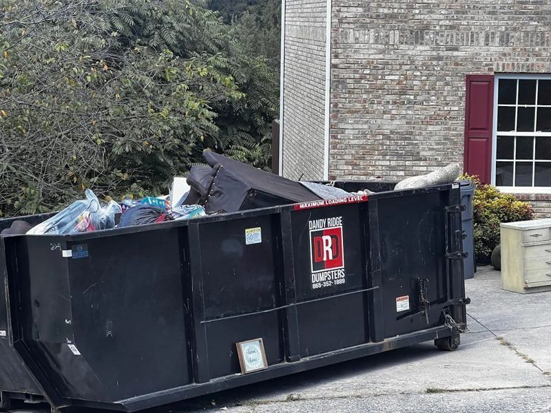 A Dandy Ridge Dumpsters roll-off loaded with roofing shingles from a tear-off in Jefferson County, TN