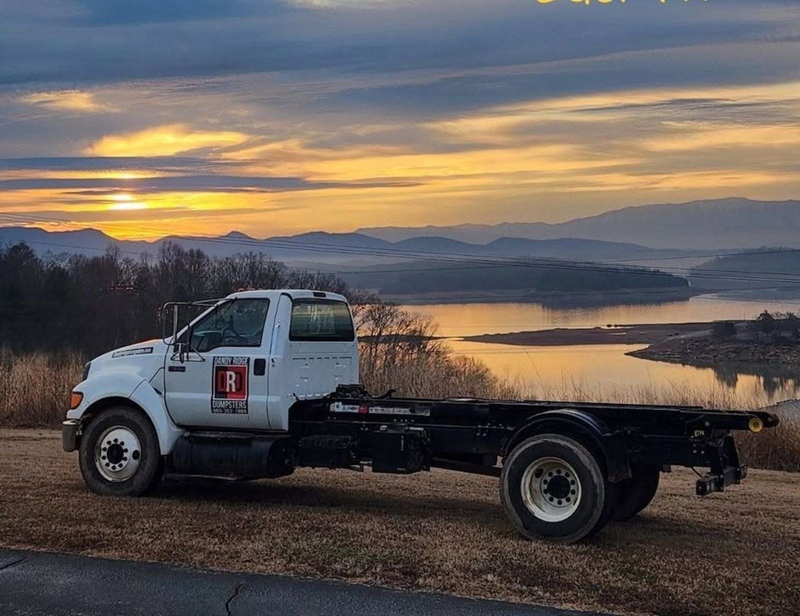 A Dandy Ridge Dumpsters roll-off truck above Douglas Lake near Dandridge, Tennessee at sunset